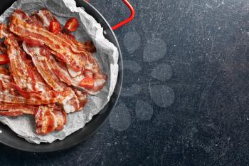 Dish with tasty bacon on grey background�