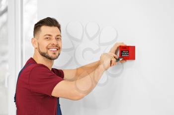 Electrician installing fire alarm system�