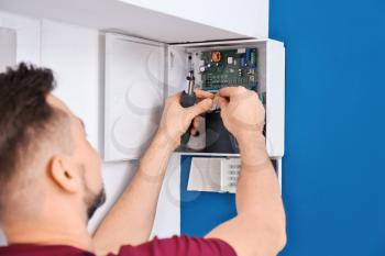 Electrician installing alarm system�
