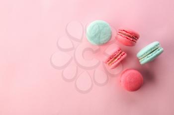 Tasty macarons on color background, top view�