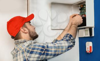 Young electrician installing alarm system�