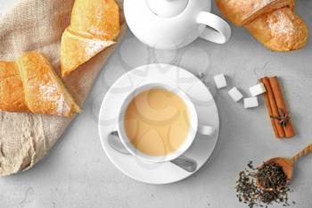 Cup of aromatic tea with milk on table, top view�