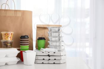 Paper bag, boxes and coffee cups on table against light background. Food delivery�
