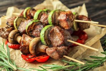 Barbecue skewers with juicy meat and vegetables on parchment�