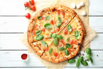 Delicious pizza Margherita on wooden background�