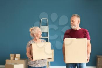Mature couple with moving boxes at new home�