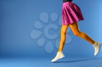 Legs of beautiful young woman wearing tights and skirt on color background�