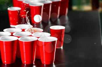 Cups and plastic ball for beer pong game on table�