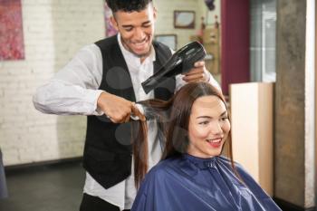 Professional hairdresser working with client in beauty salon�