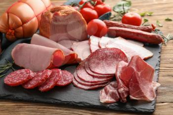 Assortment of delicious deli meats on slate plate�