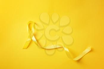 Yellow ribbon on color background. Cancer concept�