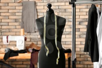 Tailor's mannequin with measuring tape in atelier�