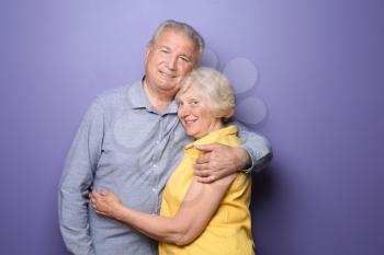 Happy senior couple on color background�