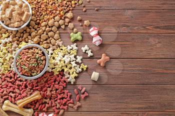 Different pet food on wooden background�
