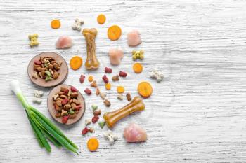 Composition with pet food and different products on wooden background�