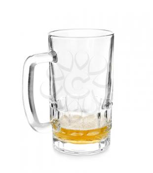 Almost empty mug of cold beer on white background�