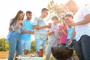 Young people having barbecue party in park�