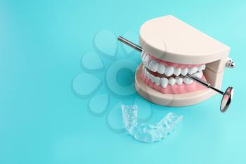 Artificial jaw, dental mirror and occlusal splint on color background�
