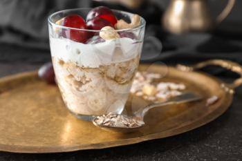Tray with tasty oatmeal dessert in glass on table, closeup�