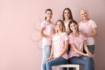 Beautiful women of different ages with pink ribbons on color background. Breast cancer concept�