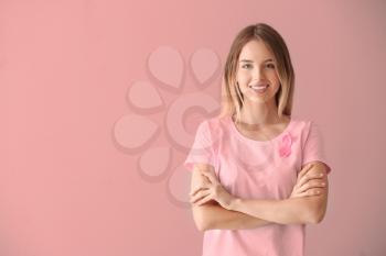 Beautiful woman with pink ribbon on color background. Breast cancer concept�