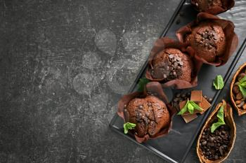 Plate with tasty chocolate muffins on grey table�
