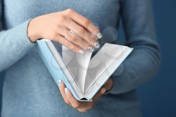 Young woman with beautiful manicure holding notebook, closeup�