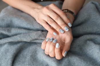 Young woman showing beautiful manicure on blanket, closeup�