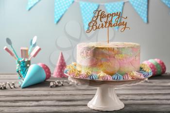 Stand with delicious birthday cake on wooden table�