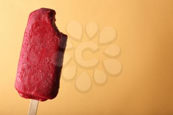 Delicious strawberry popsicle on color background�