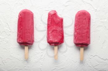 Delicious strawberry popsicles on light background�