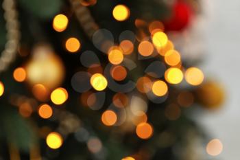 Blurred view of fir tree with glowing Christmas lights, closeup�