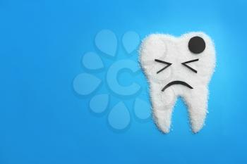 Molar tooth made of sugar on color background. Healthy teeth concept�