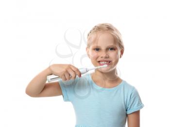 Cute little girl brushing teeth on white background 
