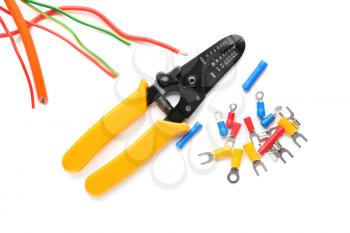 Wire stripper with cables and terminal ends on white background�