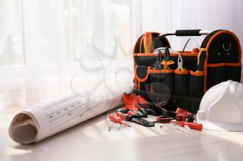 Bag with different electrician's tools and scheme on floor�
