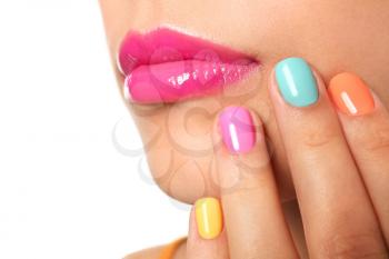 Beautiful young woman with colorful manicure on white background, closeup�