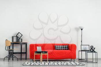 Stylish furniture with comfortable sofa near light wall�