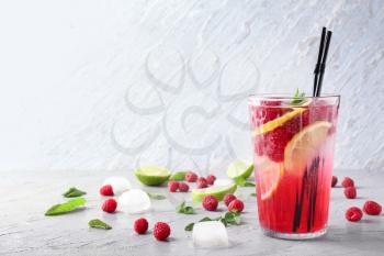 Glass of fresh raspberry mojito on table�