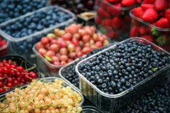 Containers with different ripe berries at market�