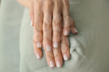 Female hands with stylish manicure on color fabric, closeup�
