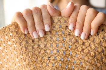Woman with stylish color nails holding straw hat, closeup�