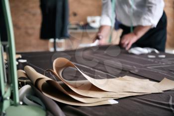 Sewing patterns on fabric in tailor's workshop�