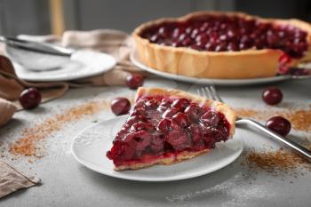 Plate with piece of tasty homemade cherry pie on table�