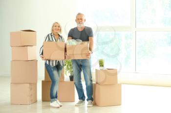 Mature couple with boxes indoors. Moving into new house�