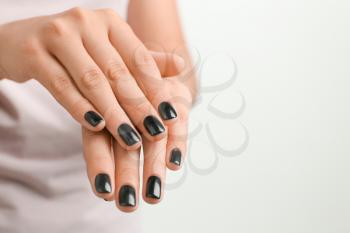 Woman with stylish black manicure on white background, closeup�