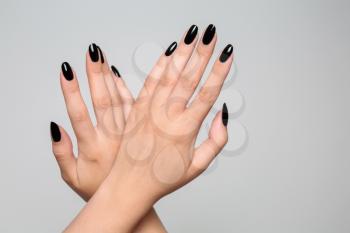 Hands of beautiful woman with professional manicure on grey background�