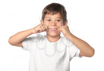 Cute little boy flossing his teeth on white background�