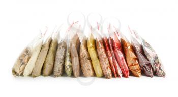 Different spices in plastic bags on white background�