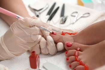 Young woman getting professional pedicure in beauty salon, closeup�